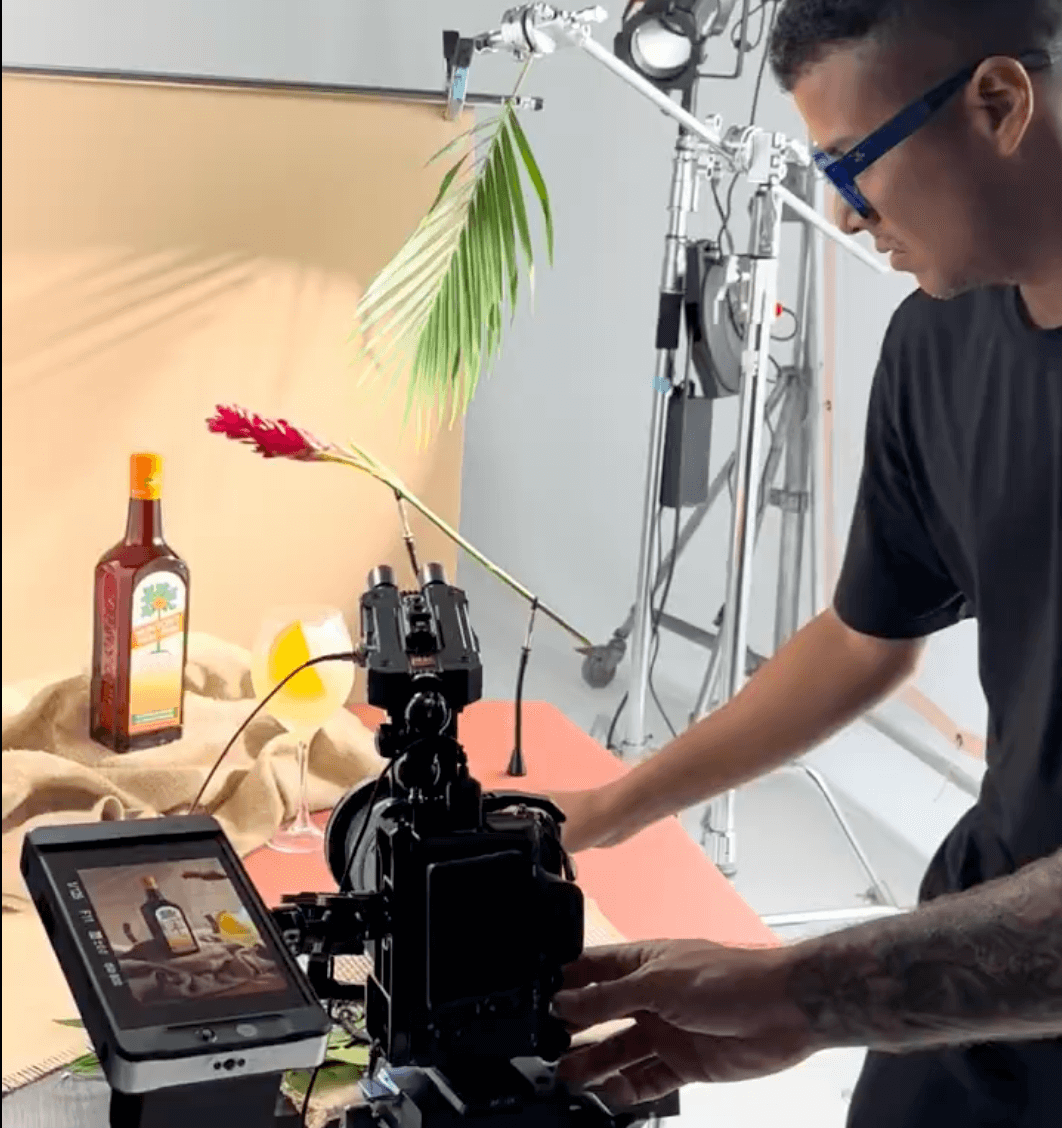 Photographer setting up a studio shot of a Munyon’s Paw-Paw liqueur bottle with a cocktail